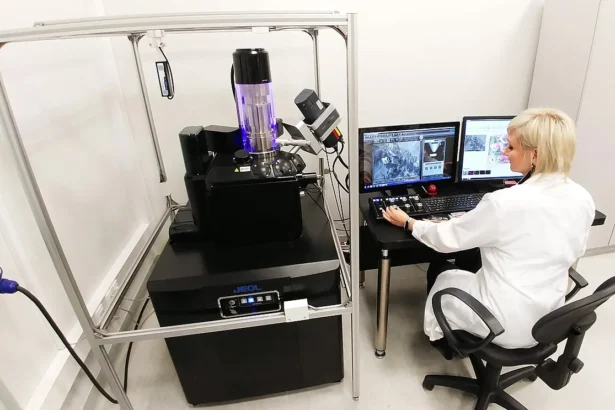 Scientist working with a scanning electron microscope in a lab