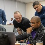 Cyber security team monitoring computer systems at workstations