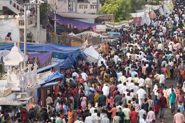 A dense crowd of visitors moving between stalls at a festival